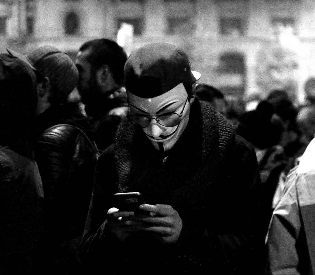 Anonymous mask + smartphone. Photo by Jake Stimpson.