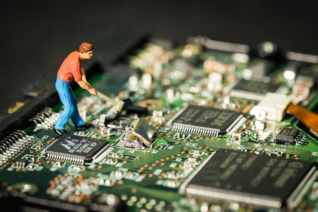 a tiny man farming a computer